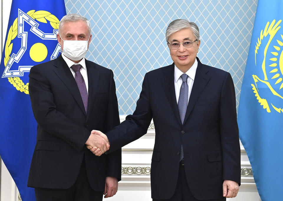 In this photo released by Kazakhstan's Presidential Press Service, Kazakhstan's President Kassym-Jomart Tokayev, right, shakes hands with Secretary General of the Collective Security Treaty Organization (CSTO), Stanislav Zas prior to their talks in Nur-Sultan, Kazakhstan, Wednesday, Jan. 12, 2022. President Kassym-Jomart Tokayev has blamed the unrest on foreign-backed "terrorists" and requested help from the Collective Security Treaty Organization, or CSTO, a Russia-led military alliance comprising of six ex-Soviet states. The bloc authorized sending 2,500 troops to Kazakhstan. Tokayev said Tuesday that the CSTO will start withdrawing its troops this week, as they have completed their mission and the situation in the country has stabilized. (Kazakhstan's Presidential Press Service via AP)