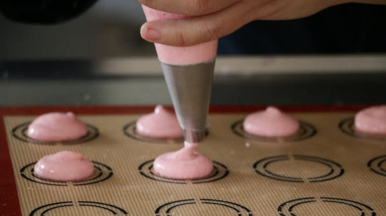 piping macaron on silicone mat