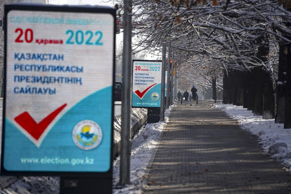 People walk down a street with election posters on the left in Almaty, Kazakhstan, Thursday, Nov. 17, 2022. Kazakhstan's president, who faced a bloody outburst of unrest early this year and then moved to marginalize some of the Central Asian country's longtime powerful figures, appears certain to win a new term against little-known challengers in a snap election on Sunday. (Vladimir Tretyakov/NUR.KZ via AP)