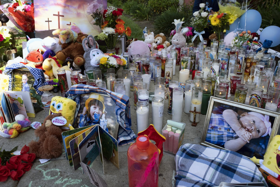 Photos of three children are placed at a memorial with candles, flowers and balloons at the scene of a crime at the Royal Villa apartments complex in the Reseda section of Los Angeles, on Monday, April 12, 2021. Authorities have identified 3-year-old Joanna Denton Carrillo, her 2-year-old brother, Terry, and 6-month-old sister, Sierra, as the three young children who were killed over the weekend. Their mother is the suspect in their deaths and was being held in a central California jail. (AP Photo/Richard Vogel)