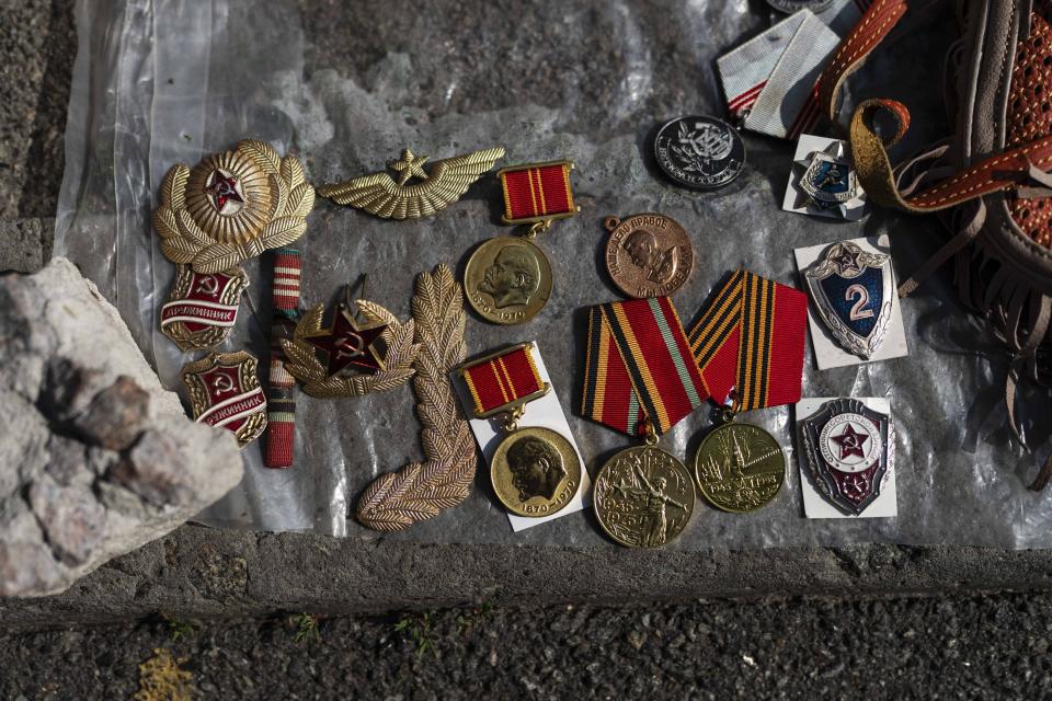 Insignias y medallas de la era soviética, a la venta en un mercado callejero en Kiev, Ucrania, el 15 de julio de 2023. A pesar de que Ucrania prohibió los símbolos soviéticos y nazis en 2015 en un intento por distanciarse de su pasado totalitario, los vendedores, los compradores y las fuerzas de seguridad parecen no alterarse con la venta a plena luz del día de estas reliquias históricas. (AP Foto/Jae C. Hong)