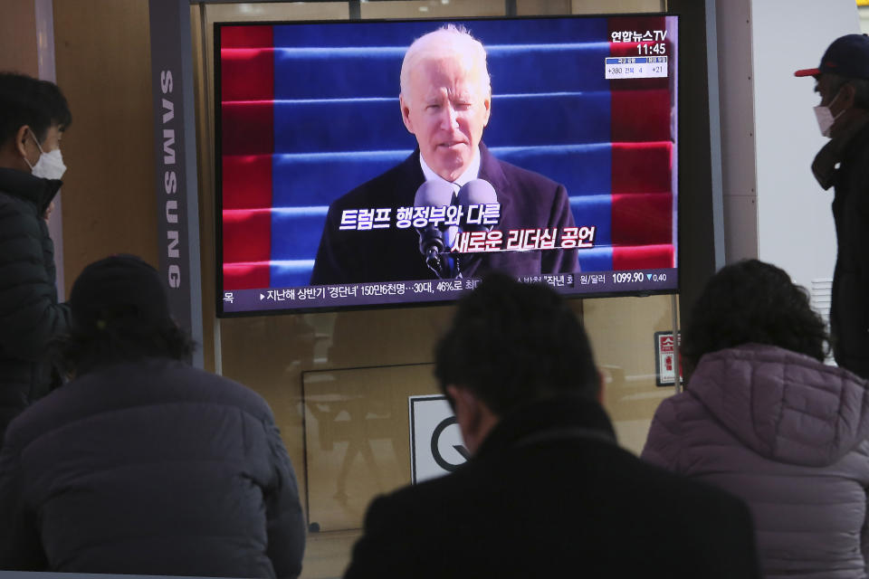 People watch a TV screen showing a news report about U.S. President Joe Biden's inauguration, at the Seoul Railway Station in Seoul, South Korea, Thursday, Jan. 21, 2021. The sign reads "New leadership." (AP Photo/Ahn Young-joon)