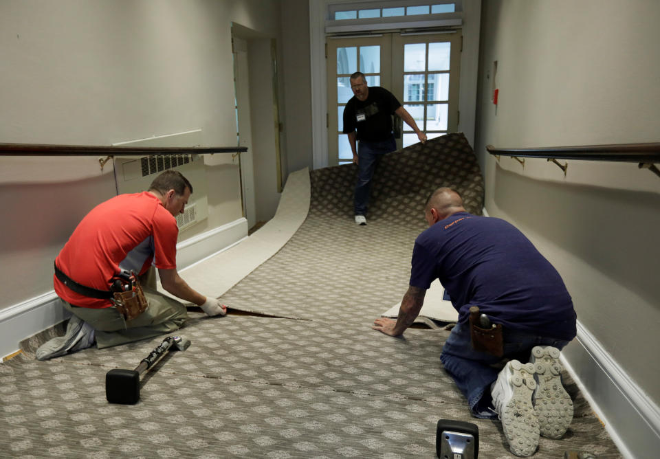 <p>Construction workers lay carpet on a ramp from the West Wing offices to the White House colonnade during renovations at the White House in Washington, Aug.11, 2017. (Photo: Jim Bourg/Reuters) </p>