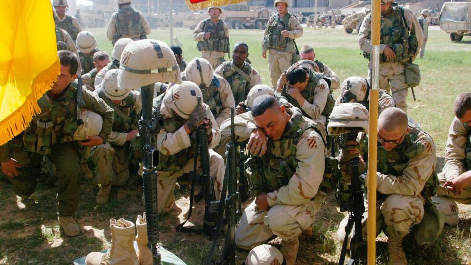 Sgt. Javier Vila, from Miami, Fla., cries as he and fellow soldiers pay their respects at a memorial service for Cpl. Henry Brown, 22, in Baghdad, Iraq Friday, April 11, 2003. Brown, who was the driver for Col. David Perkins, was killed on April 7 during a missile attack on the brigade operations center near Baghdad. Brown, 22, was from Natchez, Miss. (John Moore/AP)