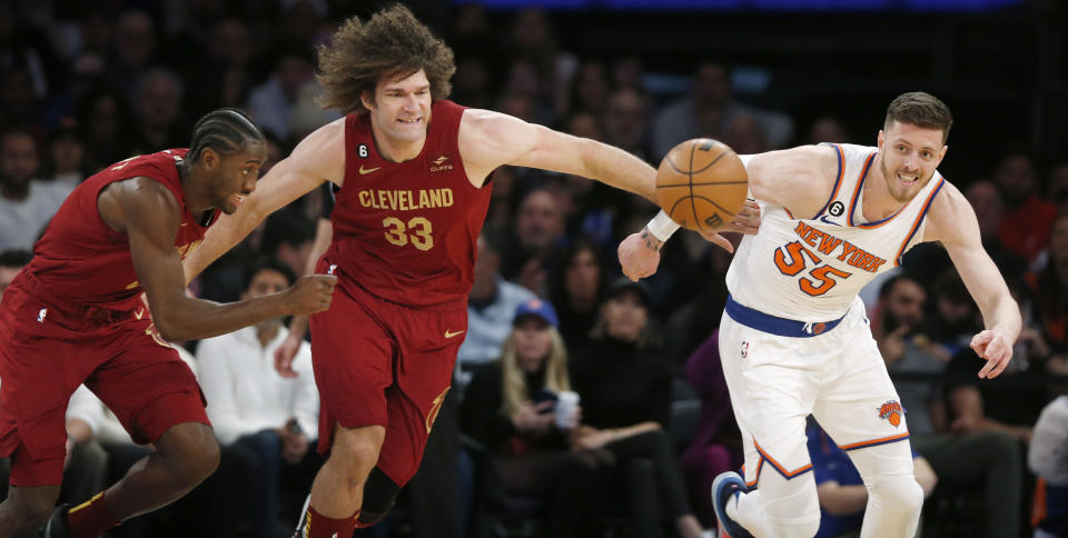 Cleveland Cavaliers guard Caris LeVert, left to right, center Robin Lopez and New York Knicks center Isaiah Hartenstein chase after a loose ball during the first half of an NBA basketball game, Sunday, Dec. 4, 2022, in New York. (AP Photo/John Munson)