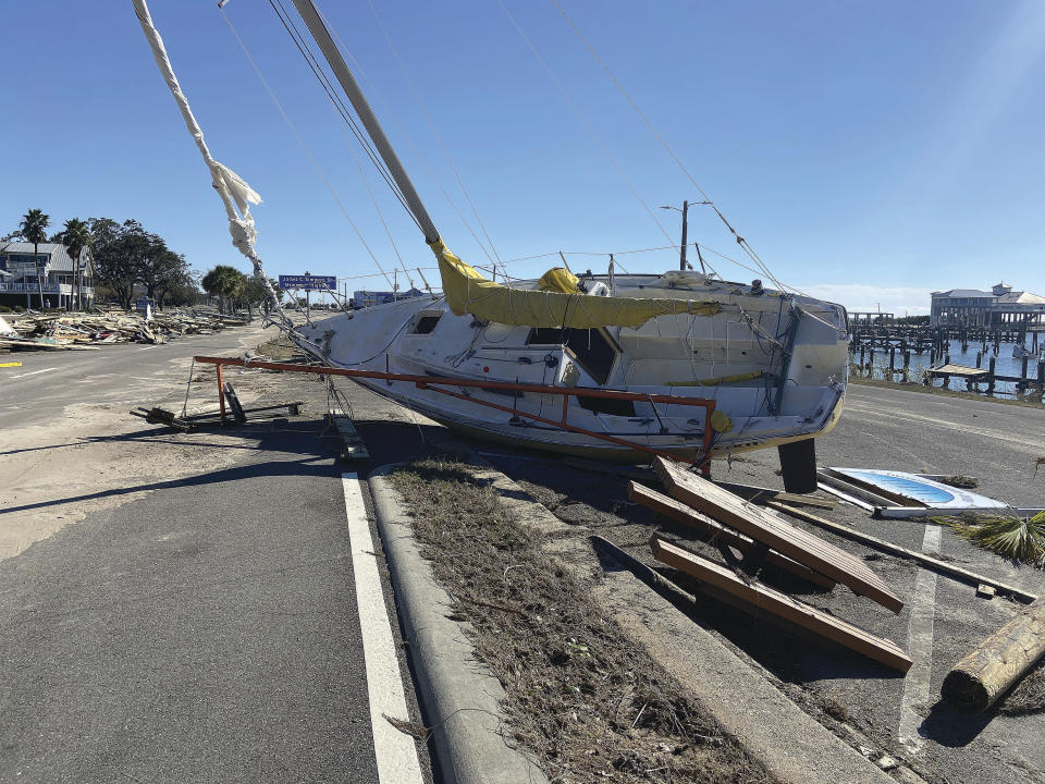 A sailboat and other debris lifted by the storm surge from Hurricane Zeta lie in the middle of Highway 90 in Pass Christian, Miss., on Thursday, Oct. 29, 2020. (Calvin Ishee/The Gazebo Gazette via AP)