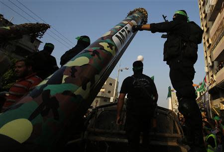 Palestinian Hamas militants stand next to M-75 home made rocket as they take part in a military parade marking the first anniversary of the eight-day conflict with Israel, in Gaza City November 14, 2013. REUTERS/Suhaib Salem