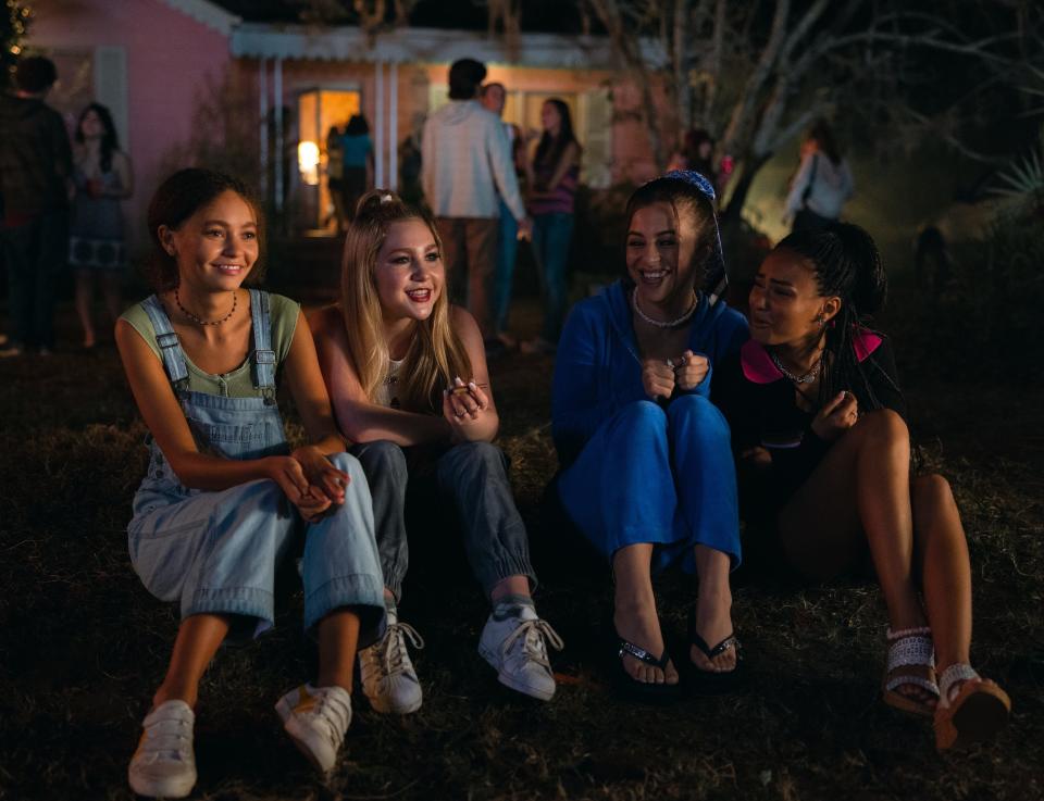 Nico Parker, Ella Anderson, Ariel Martin, and Daniella Taylor sit on a lawn outside a house in "Suncoast."