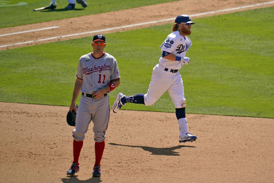 Los Angeles Dodgers' Justin Turner, right, rounds first base past Washington Nationals first baseman Ryan Zimmerman (11) after hitting a solo home run in the sixth inning of a baseball game, Friday, April 9, 2021, in Los Angeles. (AP Photo/Marcio Jose Sanchez)