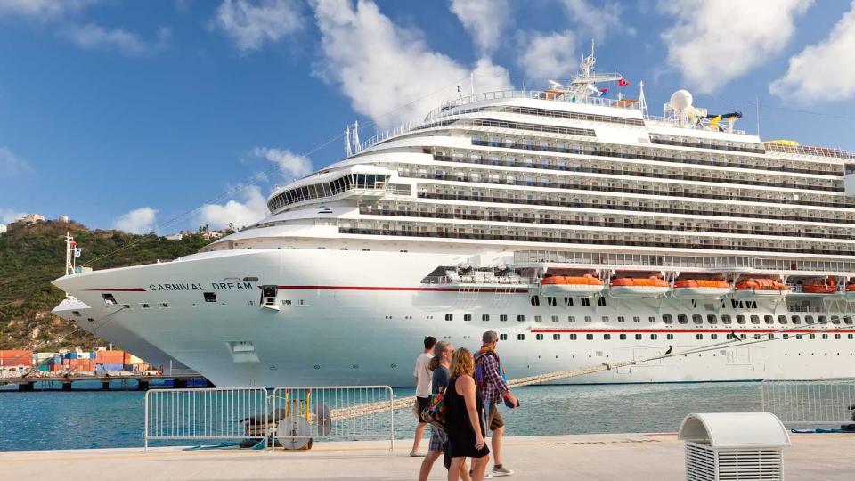 Cruise passengers on a pier with a ship in the background