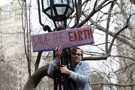 A student holds a placard during a demonstration against climate change in New York, U.S., March 15, 2019. REUTERS/Shannon Stapleton