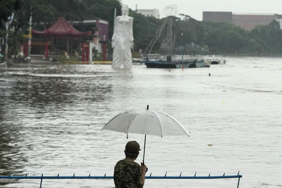 A man looks at a riverside park that was flooded due to enhanced rains brought about by Typhoon Doksuri on Thursday, July 27, 2023, in Marikina city, Philippines. Typhoon Doksuri lashed northern Philippine provinces with ferocious wind and rain Wednesday, leaving several people dead and displacing thousands of others as it blew roofs off houses, flooded low-lying villages and triggered dozens of landslides, officials said. (AP Photo/Aaron Favila)