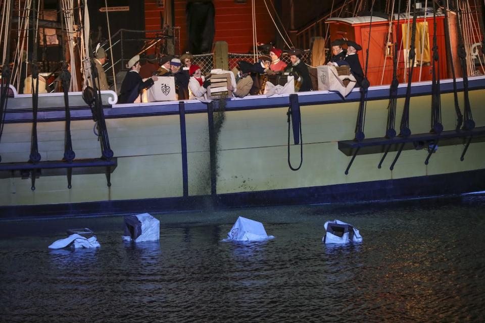 Reenactors, here in 2017, dump tea into Boston Harbor from a ship at the Boston Tea Party Museum during annual celebrations and commemorations of the event. <a href="https://www.gettyimages.com/detail/news-photo/re-enactors-dump-tea-in-the-boston-harbor-at-tea-party-news-photo/1731050601" rel="nofollow noopener" target="_blank" data-ylk="slk:Nicolaus Czarnecki, MediaNews Group/Boston Herald via Getty Images;elm:context_link;itc:0;sec:content-canvas" class="link ">Nicolaus Czarnecki, MediaNews Group/Boston Herald via Getty Images</a>