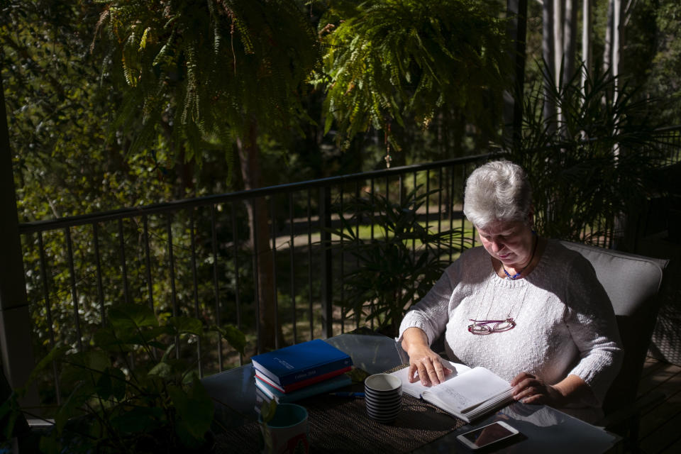 Deb Ware logs an entry in her diary at her home in Fountaindale, Central Coast, Australia, Friday, July 19, 2019. Deb has chronicled the swiftness of her son's downfall in her diary, her fury and fear catalogued alongside all the drugs, the hospitalizations and the broken promises. (AP Photo/David Goldman)