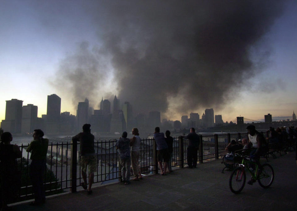 <p>Pedestrians on Pierrepont Place in the Brooklyn borough of New York, watch as smoke billows from the remains of the World Trade Center in New York, Sept. 11, 2001. (AP Photo/Lawrence Jackson)</p> 