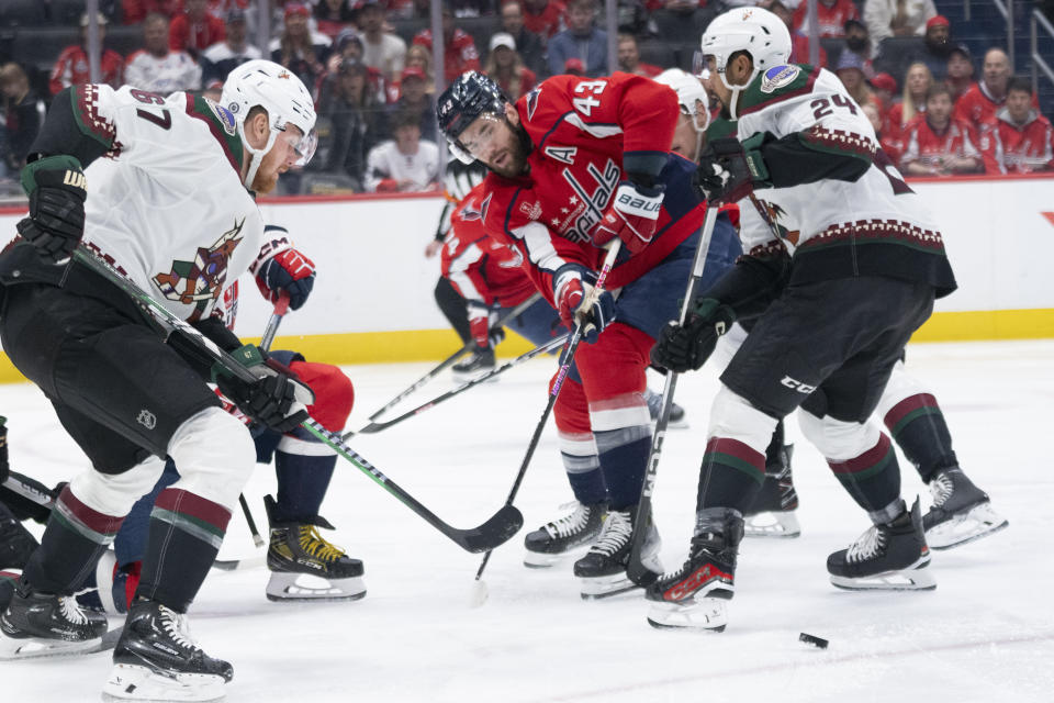 Arizona Coyotes left wing Lawson Crouse (67) and defenseman Matt Dumba, right, clear the puck from Washington Capitals right wing Tom Wilson (43) during the first period of an NHL hockey game, Sunday, March 3, 2024, in Washington. (AP Photo/Manuel Balce Ceneta)