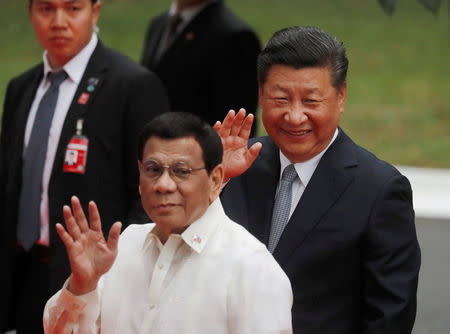 Visiting Chinese President Xi Jinping and Philippine President Rodrigo Duterte wave to the media before their one on one meeting at the Malacanang presidential palace in Manila, Philippines, November 20, 2018. REUTERS/Erik De Castro