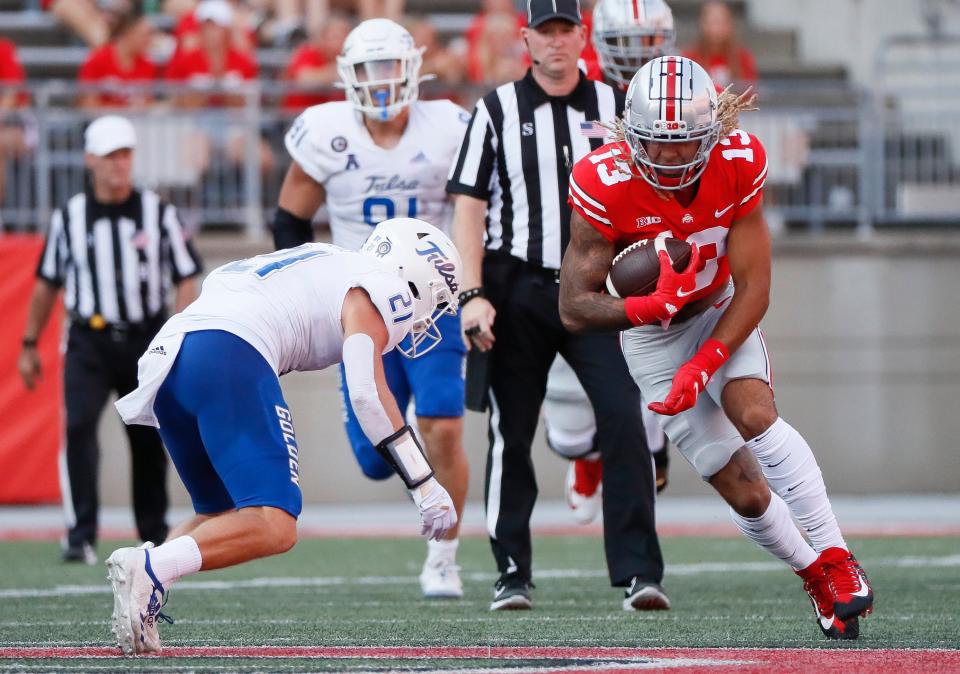 Ohio State Buckeyes tight end Gee Scott Jr. (13) runs after making a catch toward Tulsa Golden Hurricane safety Bryson Powers (21) during the third quarter of the NCAA football game at Ohio Stadium in Columbus on Saturday, Sept. 18, 2021.