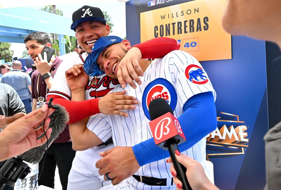 Former Chicago Cubs catcher Willson Contreras, now with the St. Louis Cardinals, is interviewed as his brother, former Atlanta Braves catcher William Contreras, now with the Milwaukee Brewers, sneaks up behind him at All Star-Media Day at Dodger Stadium on July 18, 2022.