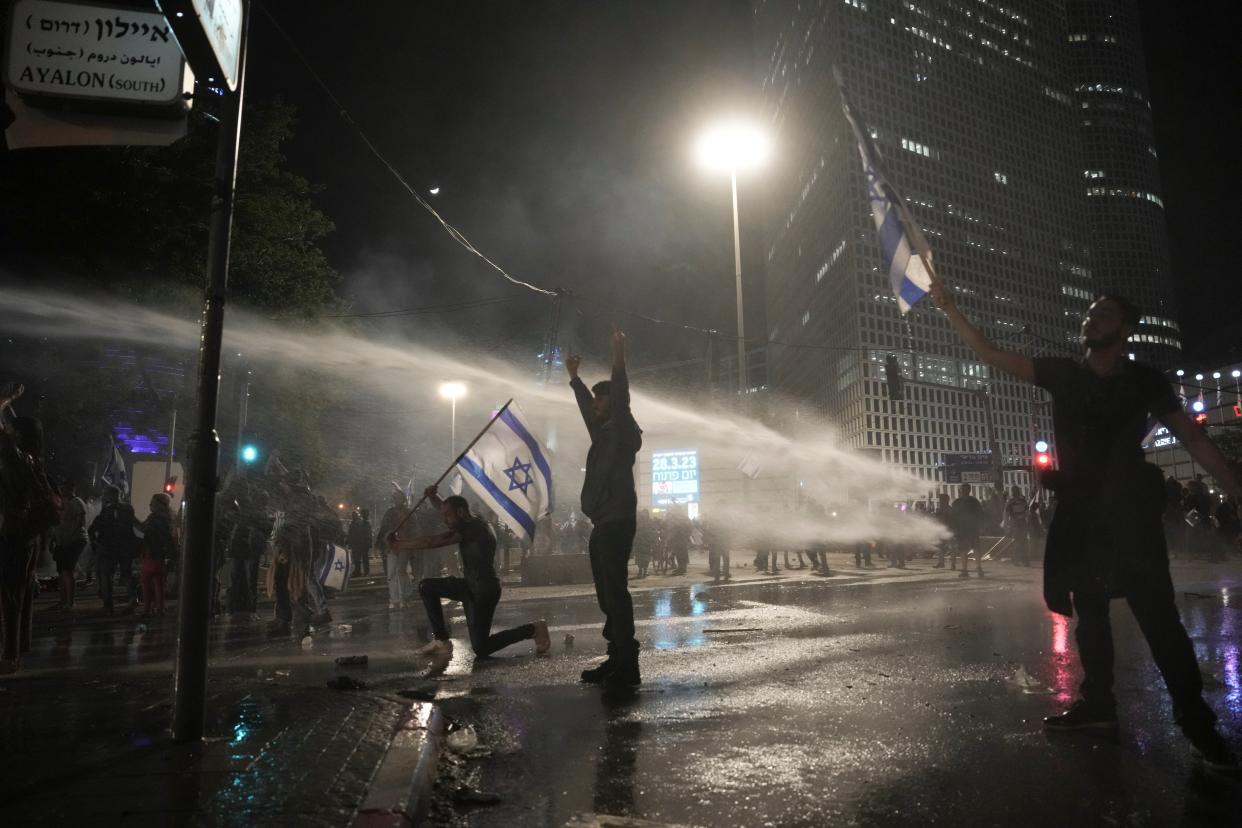 Israeli security forces use water canons to disperse protesters during ongoing demonstrations in Tel Aviv on March 27, 2023 (AP)