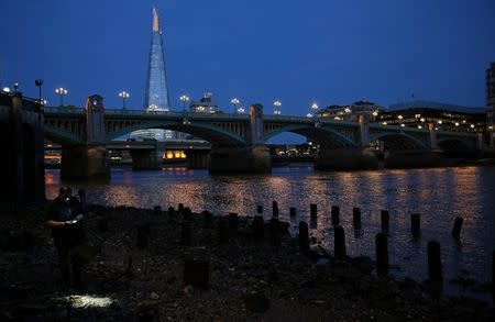 A mudlark uses a head torch to look for objects on the bank of the River Thames in London, Britain June 06, 2016. REUTERS/Neil Hall