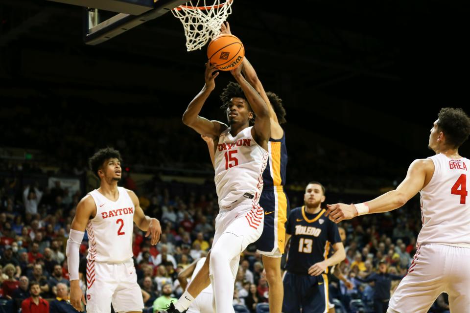 Dayton Flyers forward DaRon Holmes II (15) grabs a rebound while Dayton Flyers forward Toumani Camara (2), Toledo Rockets center Mihai Carcoana (13), and Dayton Flyers guard Koby Brea (4) look on during a first-round basketball game of the National Invitational Tournament in Toledo on March 16, 2022.