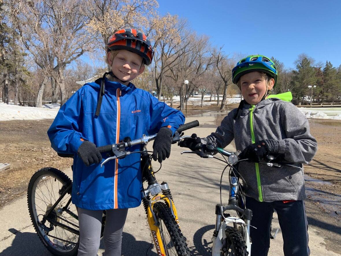 Eleven-year-old Edward Mayoh-Bauche and nine-year-old Arthur Mayoh-Bauche were out biking around Wascana Lake on Tuesday. They say they are happy with the warm weather.  (Laura Sciarpelletti/CBC - image credit)