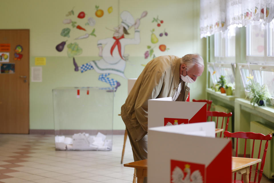 A man prepares to cast his vote during the presidential election runoff in Rybnik, Poland, Sunday, July 12, 2020. Voting started Sunday in Poland's razor-blade-close presidential election runoff between the conservative incumbent Andrzej Duda and liberal, pro-European Union Warsaw Mayor Rafal Trzaskowski. (AP Photo/Petr David Josek)