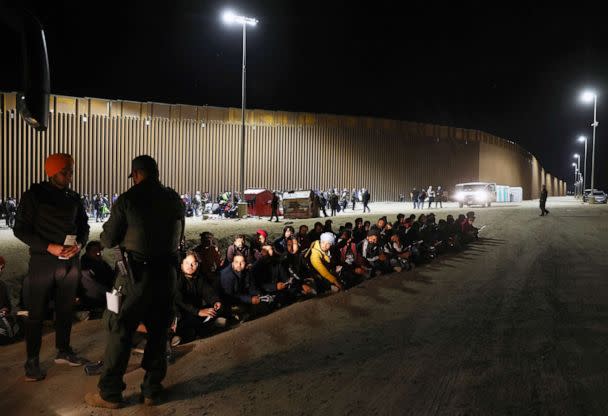 PHOTO: In this May 22, 2022, file photo, immigrants from India wait to board a U.S. Border Patrol bus to be taken for processing after crossing the border from Mexico, in Yuma, Ariz. (Mario Tama/Getty Images, FILE)