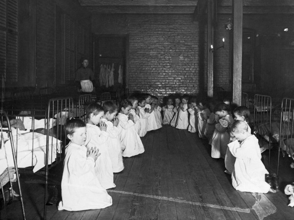 Orphan boys hold their hands together in prayer before bedtime in Five Points, New York City, circa 1889.