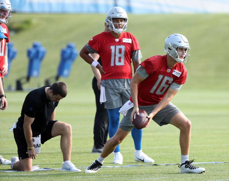 Detroit Lions quarterback Jared Goff (16) practices during training camp in Allen Park, Tuesday, July 25, 2023. Quarterback Adrian Martinez (18) watches in the background.