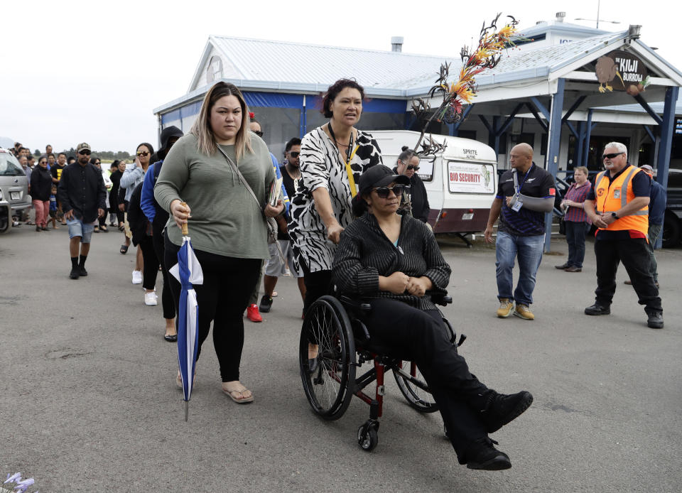 Families of victims of the White Island eruption walk to a nearby marae after arriving back to the Whakatane wharf following a blessing at sea ahead of the recovery operation off the coast of Whakatane New Zealand, Friday, Dec. 13, 2019. A team of eight New Zealand military specialists landed on White Island early Friday to retrieve the bodies of victims after the Dec. 9 eruption. (AP Photo/Mark Baker)