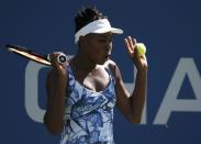 Venus Williams of the U.S. reacts an insect while preparing to serve to Kimiko Date-Krumm of Japan during their match at the 2014 U.S. Open tennis tournament in New York, August 25, 2014. REUTERS/Mike Segar (UNITED STATES - Tags: SPORT TENNIS)