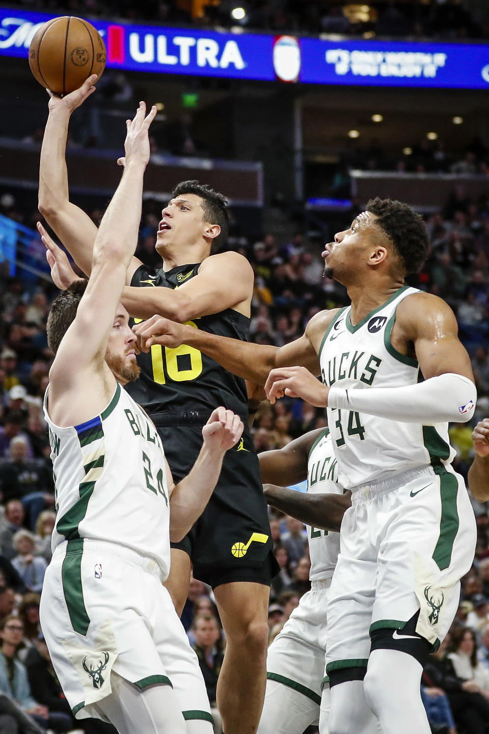 Utah Jazz forward Simone Fontecchio (16) shoots past the defense of Milwaukee Bucks guard Pat Connaughton (24) and Milwaukee Bucks forward Giannis Antetokounmpo (34) during the first half of an NBA basketball game Friday, March 24, 2023, in Salt Lake City. (AP Photo/Adam Fondren)