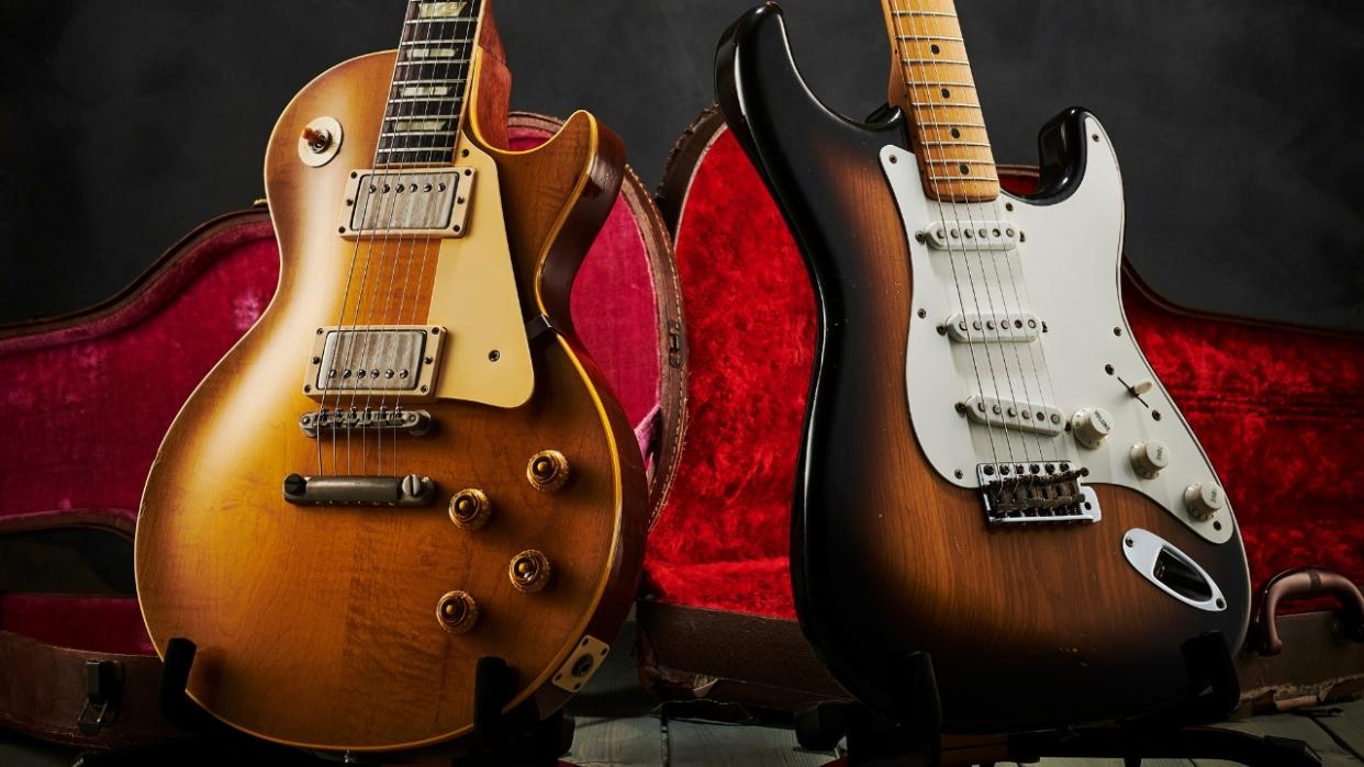  A Gibson Les Paul and Fender Stratocaster on a pair of guitar stands. 