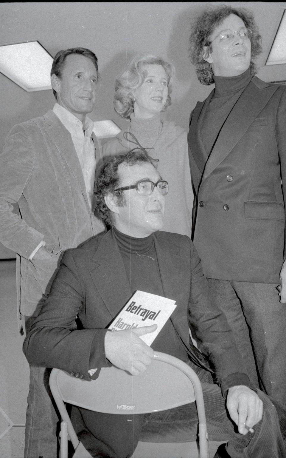 Playwright Harold Pinter seated in front of (L-R) Roy Scheider, Blythe Danner and Raul Julia. Pinter is holding a copy of Betrayal.