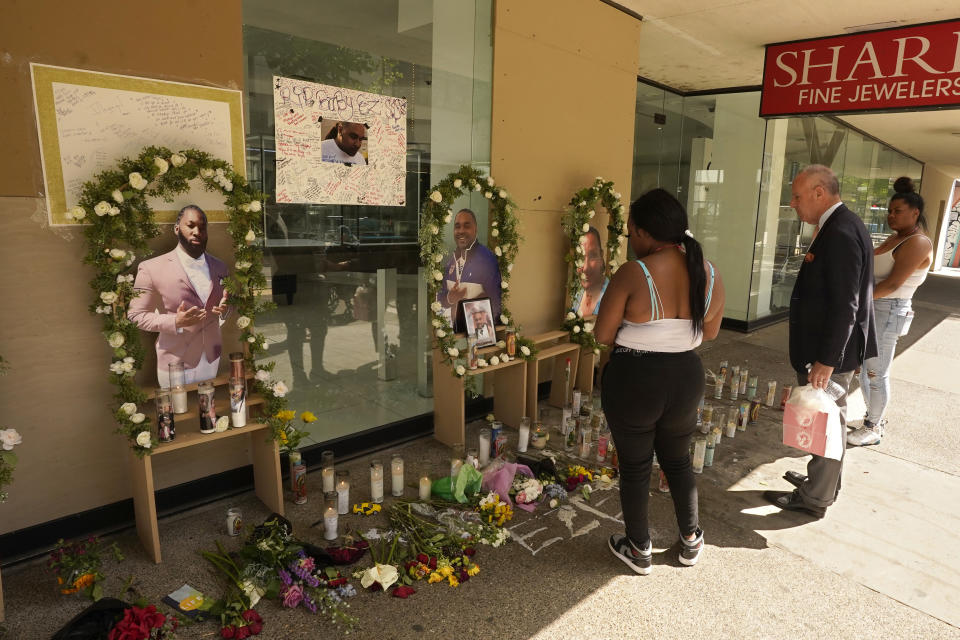 Sacramento Mayor Darrell Steinberg, center, joins two others at a memorial for the six people killed in mass shooting in Sacramento, Calif., on Wednesday, April 6, 2022. Multiple people were killed and injured in the shooting that occurred Sunday, April, 3. (AP Photo/Rich Pedroncelli)