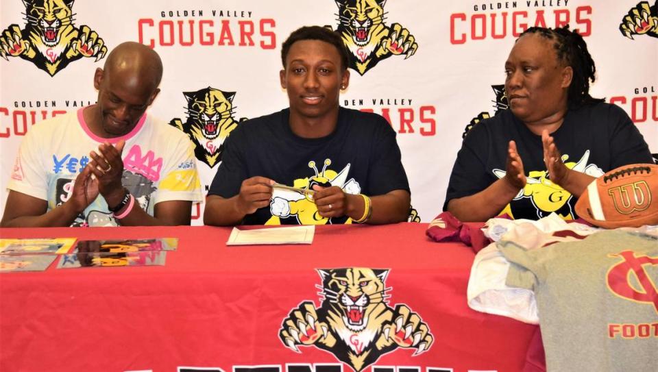 Golden Valley High School senior Jahkylle Smith signs his national letter of intent to accept a football scholarship to Graceland University in Iowa as his stepfather Duke Lane (left) and mother Chuckie Lane look on during a ceremony at Golden Valley High School on Thursday, May 18, 2023.