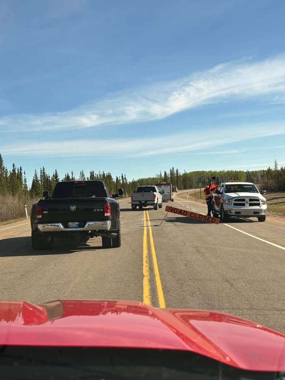 Pilot trucks escort vehicles along Highway 35 in Alberta towards the N.W.T. border on April 11, 2024.