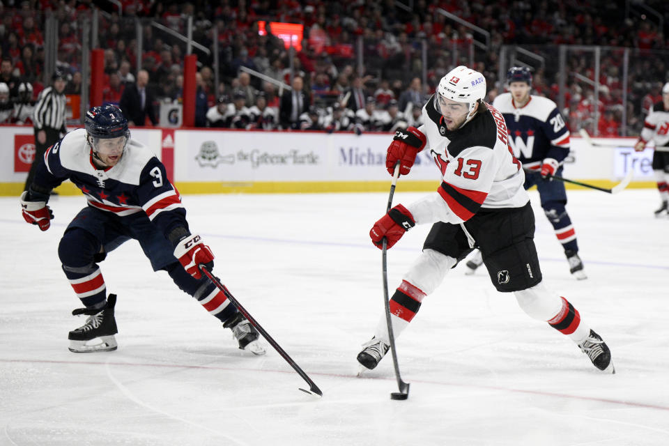 New Jersey Devils center Nico Hischier (13) shoots against Washington Capitals defenseman Nick Jensen (3) during the second period of an NHL hockey game, Saturday, March 26, 2022, in Washington. (AP Photo/Nick Wass)