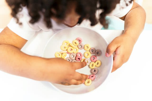 <p>Getty</p> A child eats Cheerios.