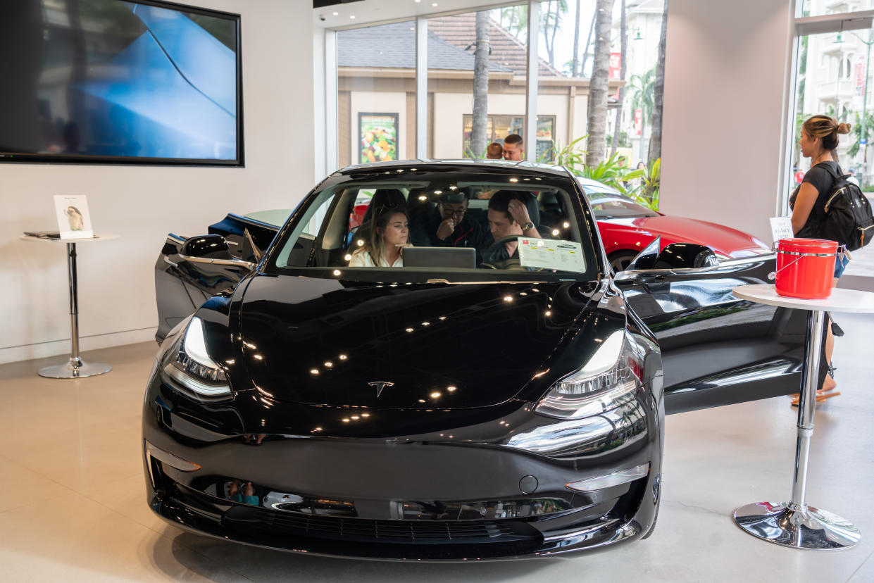 HONOLULU, UNITED STATES - 2020/03/05: Customers admire a Tesla Model 3 electric vehicle at a Tesla store. (Photo by Alex Tai/SOPA Images/LightRocket via Getty Images)