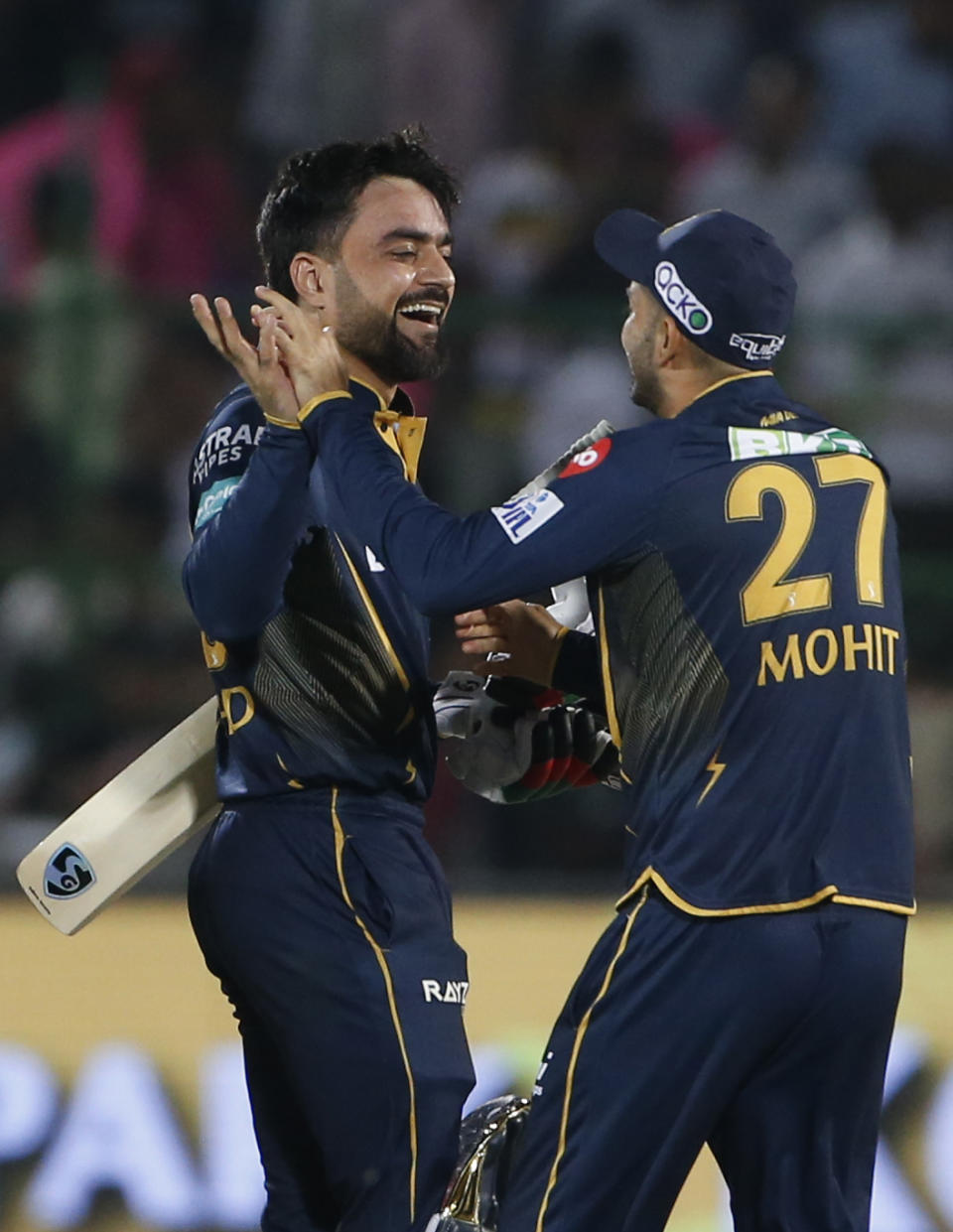 Gujarat Titans' Rashid Khan, left, celebrates with teammate Mohit Sharma after scoring the winning runs during the Indian Premier League cricket match against Rajasthan Royals in Jaipur, India, Wednesday, April 10, 2024. (AP Photo/Surjeet Yadav)