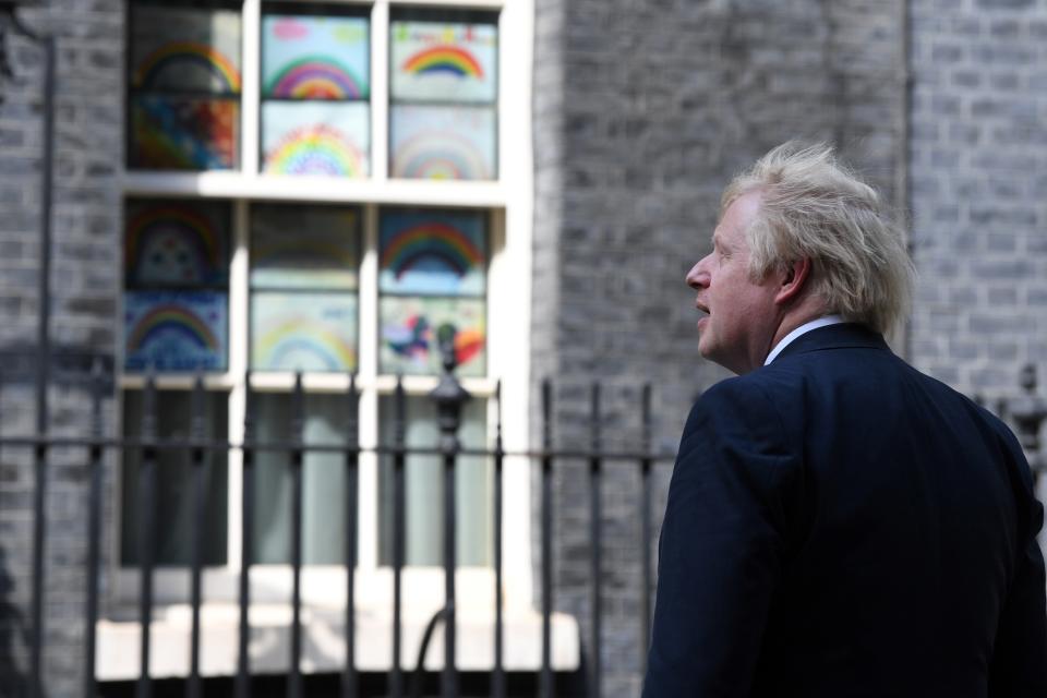 Britain's Prime Minister Boris Johnson stands outside 10 Downing Street to look at posters drown by children, of rainbows, being used as symbols of hope during the COVID-19 pandemic, and messages of thanks for the workers of Britain's NHS (National Health Service), in central London on May 15, 2020. (Photo by DANIEL LEAL-OLIVAS / AFP) (Photo by DANIEL LEAL-OLIVAS/AFP via Getty Images)