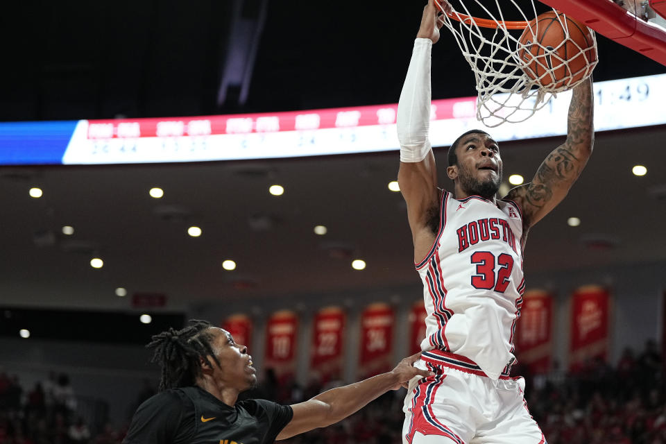 Houston forward Reggie Chaney (32) dunks the ball over Norfolk State guard Cahiem Brown (31) during the second half of an NCAA college basketball game, Tuesday, Nov. 29, 2022, in Houston. (AP Photo/Kevin M. Cox)