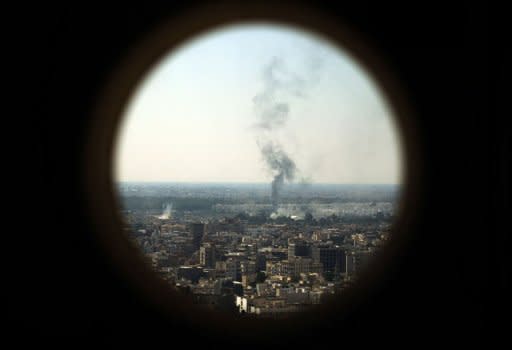 Smoke billows from the Bab al-Aziziya compound in Tripoli as Libyan rebels battle loyalists a day after it was captured by rebels