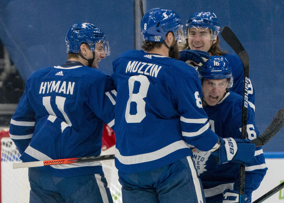 Toronto Maple Leafs center Mitchell Marner (16) celebrates his goal with teammates Jake Muzzin (8), Justin Holl (3), and Zach Hyman (11) during the first period of an NHL hockey game in Toronto on Saturday, Feb. 13, 2021. (Frank Gunn/The Canadian Press via AP)
