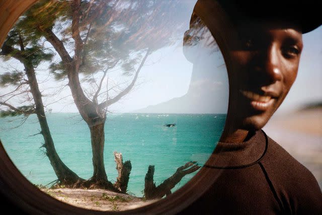 <p>Michael Turek</p> From left: The view through a porthole window in the restaurant at Kisawa; Francisco Americo Zivane, one of Kisawa’s three scuba instructors.
