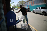 <p>Juan Rivera, from the U.S. Postal Service, picks up the mail at an area affected by Hurricane Maria in the island of Culebra, Puerto Rico, Oct.7, 2017. (Photo: Carlos Barria/Reuters) </p>