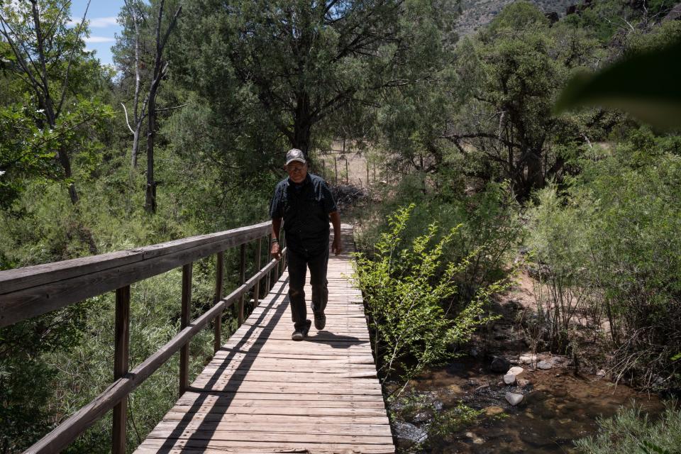 Ramon Riley, cultural resource director for the White Mountain Apache Tribe, walks across the East Fork White River on a bridge on June 19, 2023, in Fort Apache, Ariz.